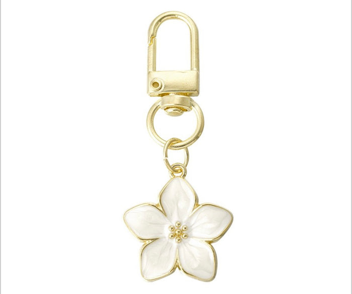 Goldfarbener Blumenanhänger mit Emaille-Blüte – Weiß