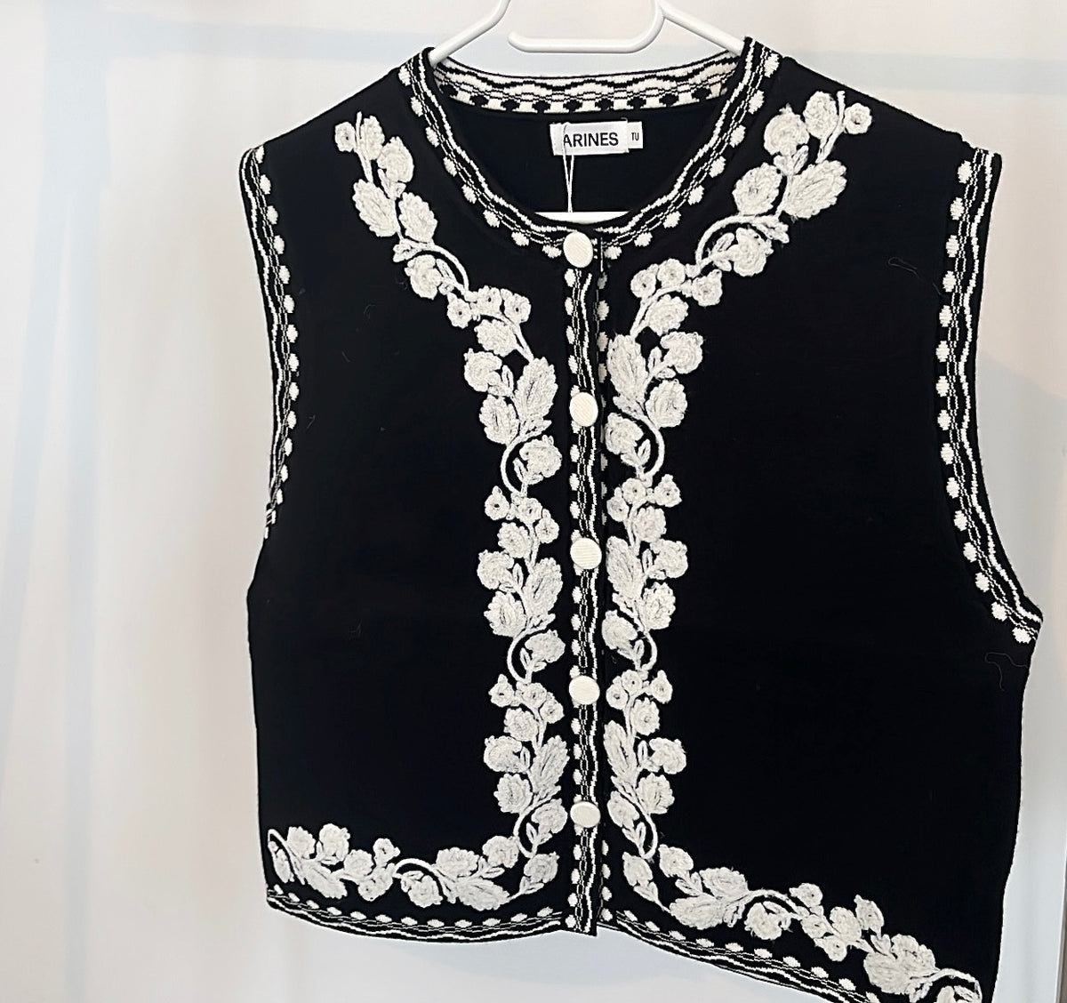 Bestickte schwarze Strickweste mit weißen Blumen
